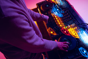 Close-up image of male hands, dj making sounds at night club party with professional sound mixer....