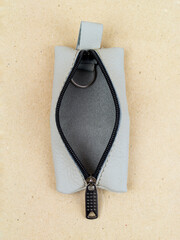 The housekeeper made of genuine leather lies on the table on paper
