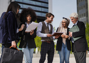 Multiracial business people analyze diagrams outdoor