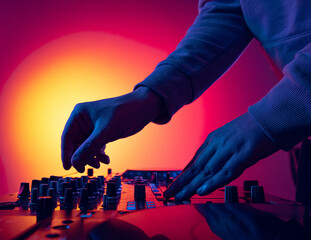 Close-up image of male hands, dj making sounds at night club party with professional sound mixer. Modern party style - obrazy, fototapety, plakaty