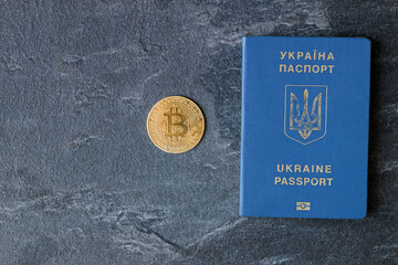 Crypto currency bitcoin lies on the passport of Ukraine on a blue background. The concept of business, mining, earnings in Ukraine.