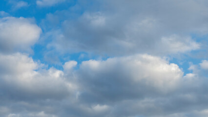 Blue sky background with clouds. White cumulus clouds in blue sky. Cloudy weather, cloudscape, copy space. Space for text.