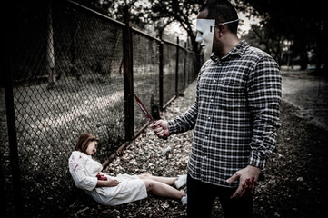 A serial killer scene is about to kill an Asian woman,concept thriller scene,Halloween festival