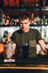 Vintage portrait of bartender creating cocktails at bar. Close up of alcoholic beverage preparation