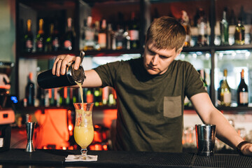 Vintage portrait of bartender creating cocktails at bar. Close up of alcoholic beverage preparation