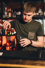 Vintage portrait of bartender creating cocktails at bar. Close up of alcoholic beverage preparation