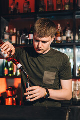 Vintage portrait of bartender creating cocktails at bar. Close up of alcoholic beverage preparation