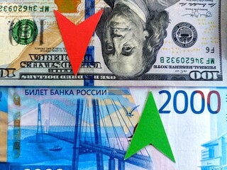 The growth of the ruble exchange rate. The fall of the dollar. Paper banknotes of Russia and America. The green arrow points up. The red arrow points down.The concept of Growth, ruble, decline dollars