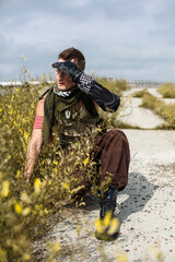 Naklejka premium male vandal in dirty clothes hiding in the grass on an abandoned bridge
