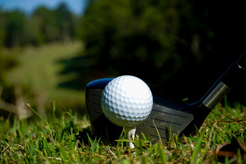 Golf clubs and balls on a green lawn in a beautiful golf course with morning sunshine. golf ball on green grass ready to hit on golf course background.