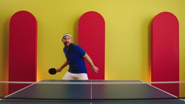 Good looking charismatic player get ready to start playing on the ping pong he dancing and moving funny exercise before game with his paddles he are all equipment