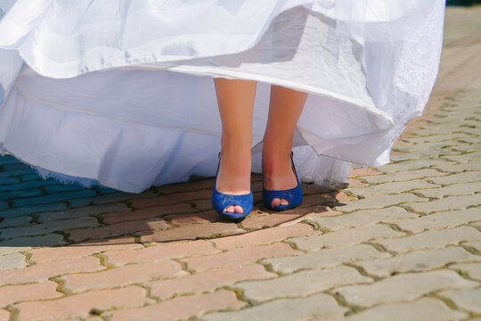 cropped image of female legs in shoes. The bride is standing on the cobblestones