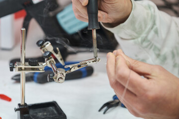 Fototapeta premium Close up of a technician tin soldering an alligator cable.
