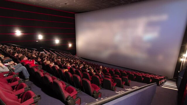 Viewers watch motion picture at movie theatre timelapse