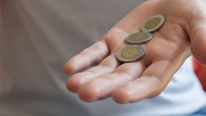 Persona con tres pesos mexicanos en la mano con fondo desenfocado - obrazy, fototapety, plakaty