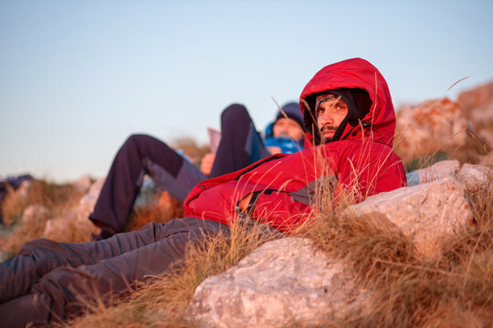 Focused young mountain climber lying and relaxing on top of the Rtanj mountain enjoying early morning views at sunrise