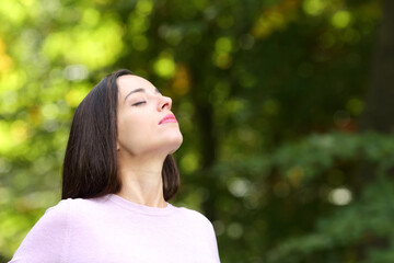 Woman relaxing breathing fresh air in a park