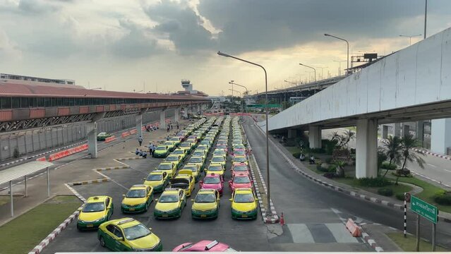 BANGKOK, THAILAND - Circa January, 2022 : Taxis cab line up outside Don Mueang International Airport. Cars park muster in row at parking lot with no passengers. Travel restriction lockdown concept
