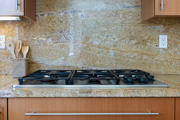 Modern kitchen detail of sandy pattern granite counter and backsplash with grill. - obrazy, fototapety, plakaty