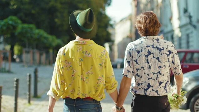 Shot back young gay couple hold hands hug each other walk at street friendship relationship lifestyle concept homosexual dating intersection travel outdoors lgbt slow motion