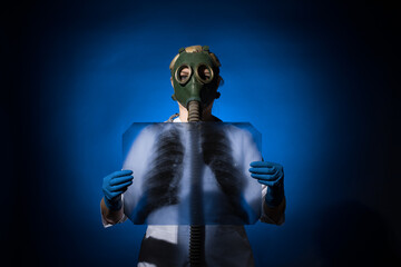doctor woman in gas mask and gloves holding x-rays on blue background