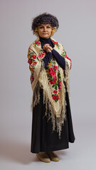 woman in a fur hat and a colored shawl on her shoulders clasped her hands on a white background