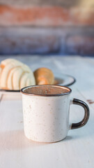 Taza de chocolate con pan de dulce con desenfoque