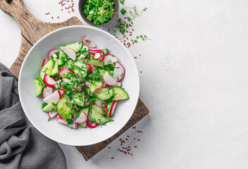 Summer vegetable salad with radishes on a gray background. Top view, space to copy.