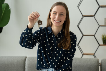 Woman showing the keys to the house, moving into the first new apartment or house, a happy...