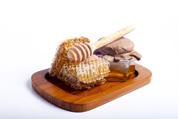 Fresh bee honey in  jar and honeycombs close-up on white background