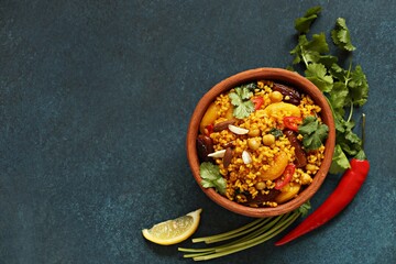 Vegan Moroccan Couscous with Chick Peas, spinach, dried apricots and date fruit. Traditional African Tajine dish. Flat layot