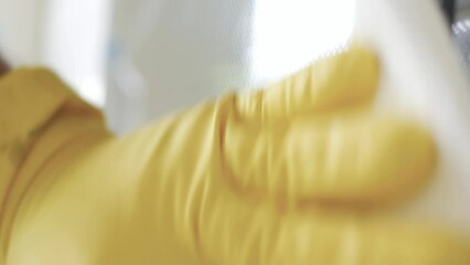 Blurred Shooting with a Man Wearing Gloves Cleaning the Cooking Stove with Spray Detergent, a Routine Activity in Kitchen Chores.