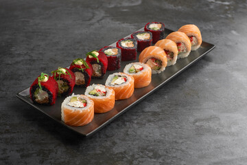 Sushi set. Roll Philadelphia, California Black, with fresh ingredients on stone background.