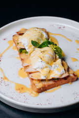 Toast with egg poached, healthy breakfast of waffles, poached egg with bacon and arugula. Brioche sandwich