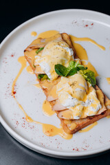Toast with egg poached, healthy breakfast of waffles, poached egg with bacon and arugula. Brioche sandwich