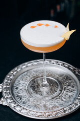 Pisco sour cocktail. Whiskey Sour in Coupe Glass with ice on gray background. Overhead view, copy space. Advertising for cafe. Bar menu.