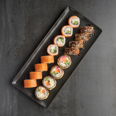 Sushi set. Roll Philadelphia, Tempura Salmon, with fresh ingredients on stone background.