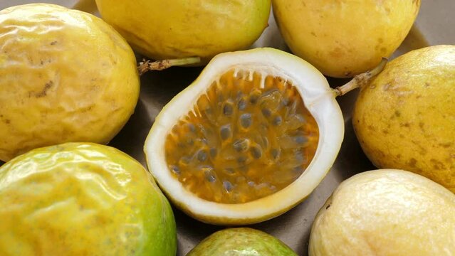 Passion fruit background with whole and one half cut chinola, top view. A lot of maracuja. Tropical fruits backdrop
