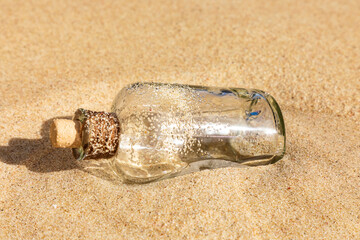 Flaschenpost im Sand an einem Strand.