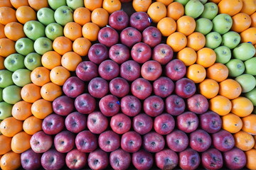 Fototapeta na wymiar geometrically arranged red apples, oranges and green apples