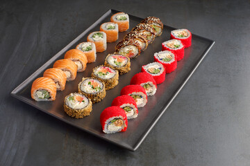 Sushi set. Roll Philadelphia, California Black, with fresh ingredients on stone background.