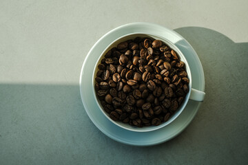 Coffee cup filled with unground coffee beans