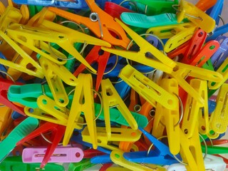 background of numerous plastic multi colored clothespins for clothes close up