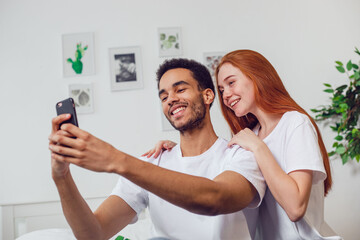 Fototapeta premium Young couple in love taking a selfie together at home.