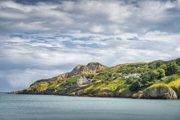 Obraz premium Beautiful Howth cliff walk with some residential houses and lush green vegetation, Dublin, Ireland