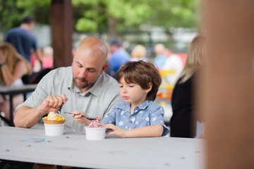 Dad and son buying and eating ice-cream in boxi parkin lake nona florida 