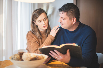 couple reading bible and pray together at home - 502264440