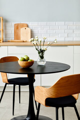 Elegant black table with two wooden chairs in modern kitchen interior, copy space