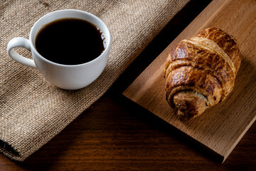 Croissant with a cup of full coffee,directly above	
