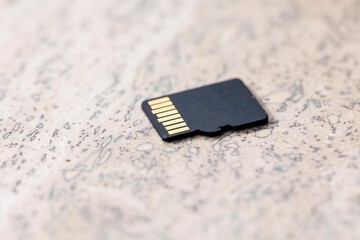 A close up portrait of the back of a black micro SD card, the connectors of the small piece of storage electronics hardware is visible.